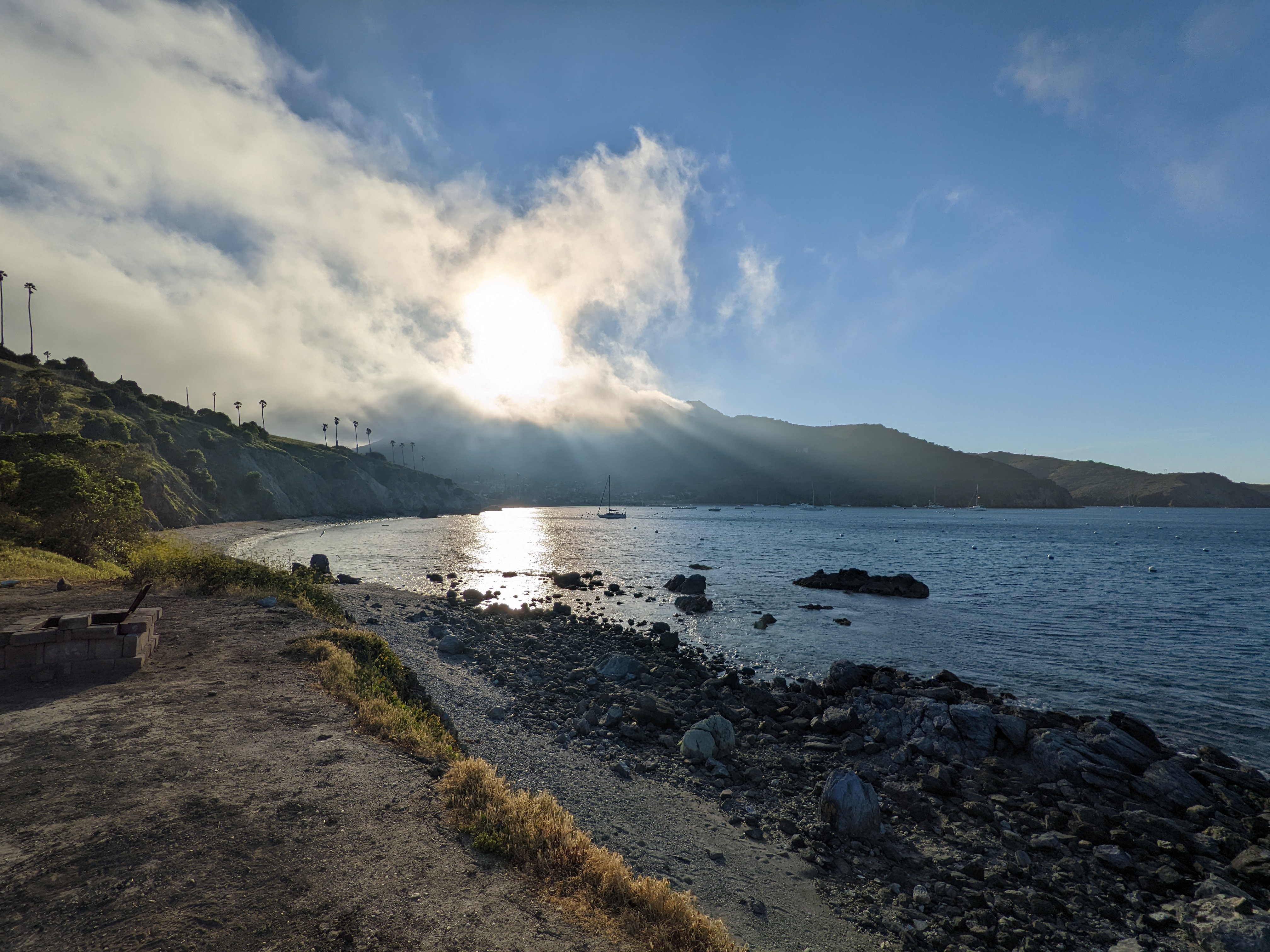 Green tent overlooking the ocean at sunset